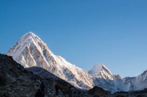Trekkers walking with Pumori peak glowing at sunrise on the Everest Base Camp Trek