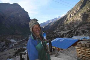 Local Nepali man smiling above a mountain village on the Annapurna Circuit Trek