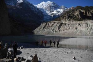 Trekkers group posing at frozen Tilicho Lake on the Annapurna Circuit Trek