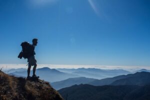 Trekker standing on a ridge overlooking layered Himalayan mountains