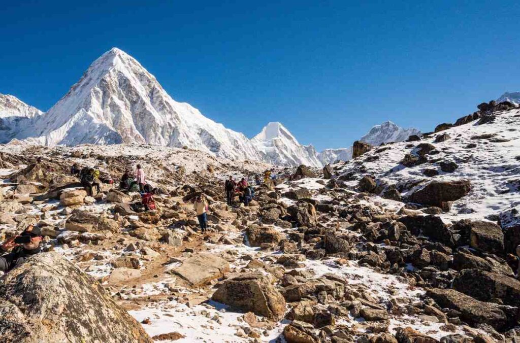 Trekkers resting at Kala Patthar with Pumori peak in the background