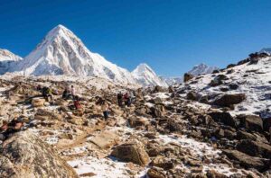 Trekkers resting at Kala Patthar with Pumori peak in the background
