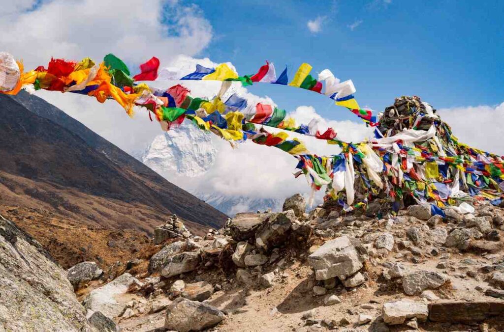 Colorful prayer flags at a memorial cairn on the Everest Base Camp Trek