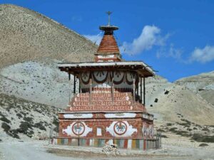 Painted Buddhist chorten against arid Mustang mountains