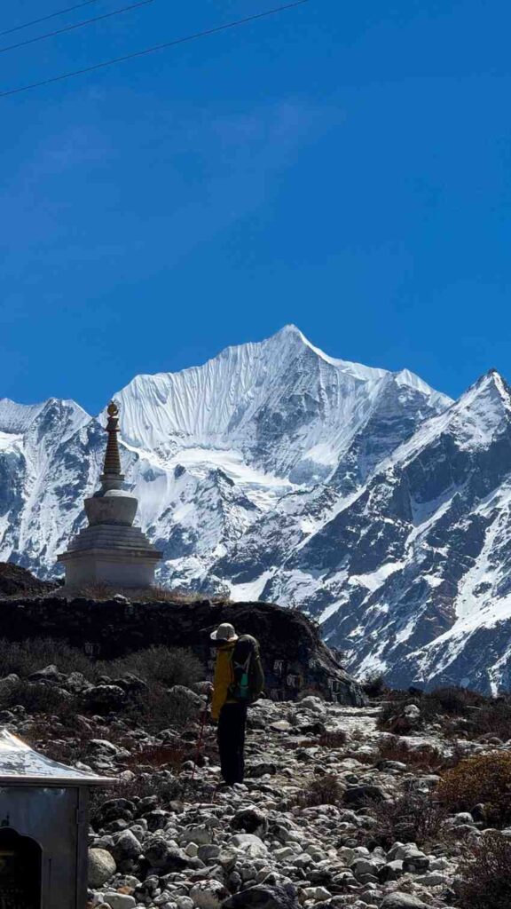 Trekker beside stupa with Langtang Lirung in view