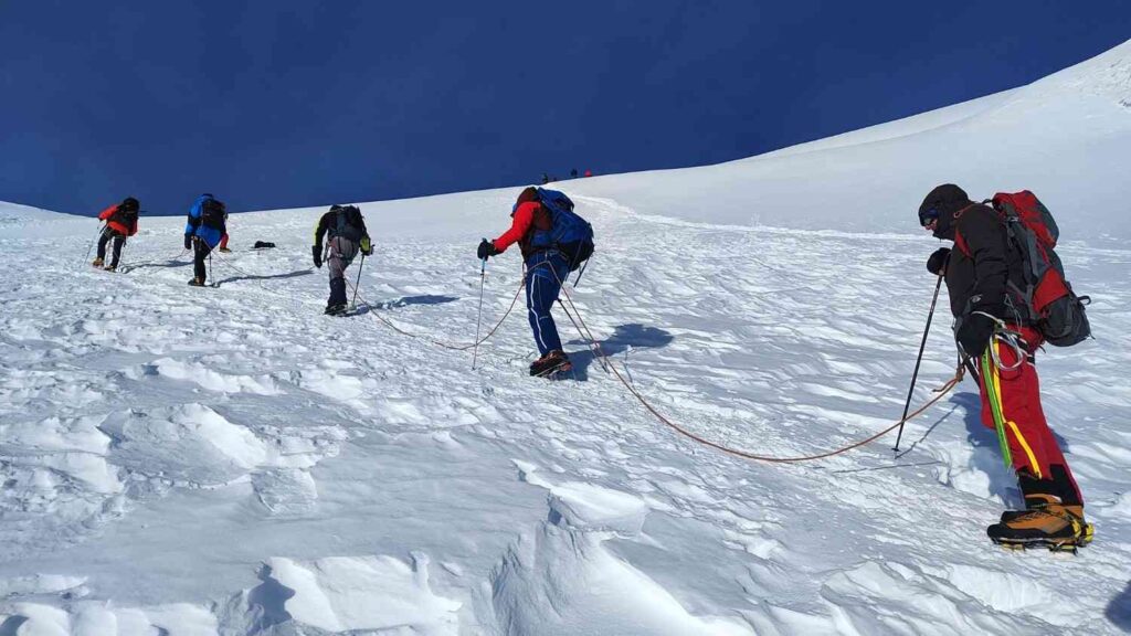 Roped climbers trekking across Island Peak glacier