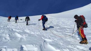 Roped climbers trekking across Island Peak glacier
